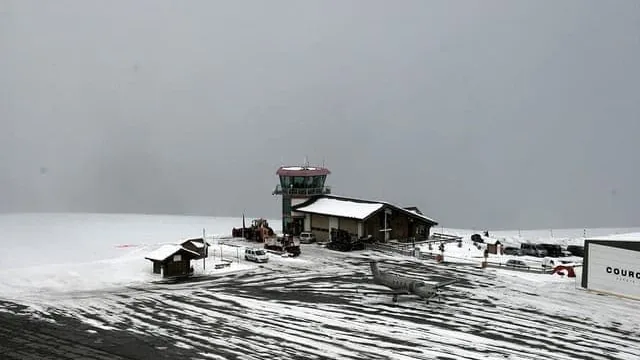 Здание и взлетно-посадочная полоса высокогорного порта под снегом