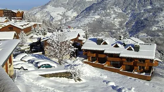 Chalets under the snow at the foot of the mountains