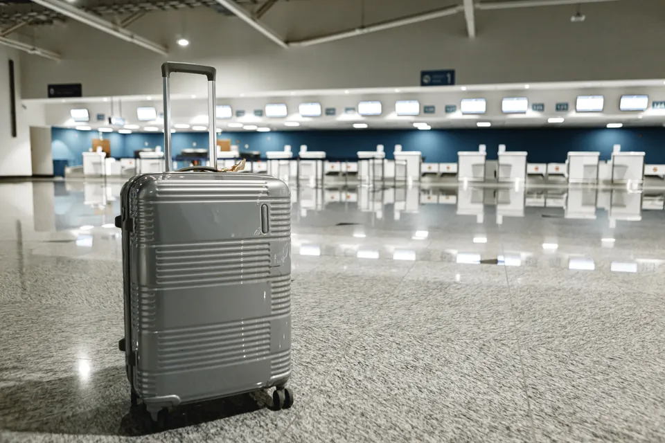 A grey suitcase in an airport terminal
